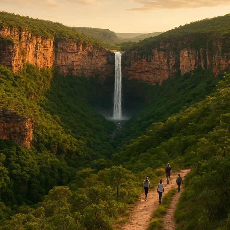 Cachoeira alta caindo entre paredoes avermelhados e vegetacao exuberante na Chapada Diamantina ao entardecer com turistas em trilha natural