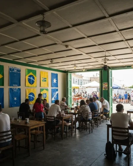 Brasil x Escócia terá transmissão em seis canais e altera rotina do Bahia Público de costas em bar assistindo várias televisões com cores do Brasil e Escócia