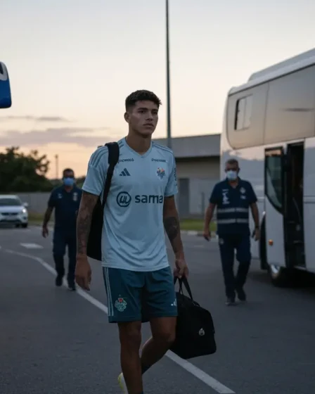 Convocado Cailan vai à seleção sub-15 e pode desfalcar o Bahia na base Jogador da base de costas caminhando no corredor do centro de treinamento, comissão técnica desfocada ao fundo